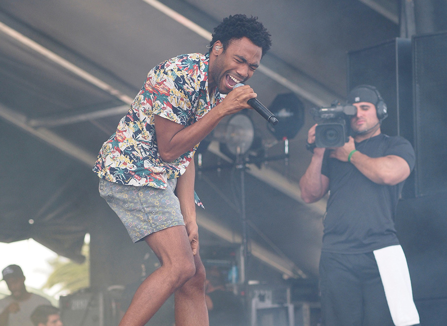 Donald Glover in camicia hawaiana e pantaloncini mentre si esibisce sul palco