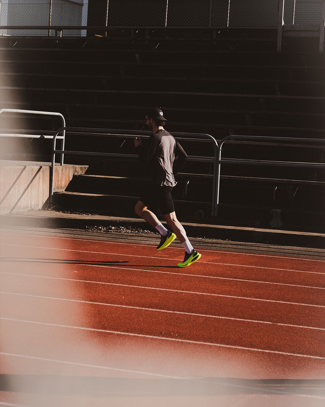 Runner che corre su una pista di atletica davanti a una tribuna