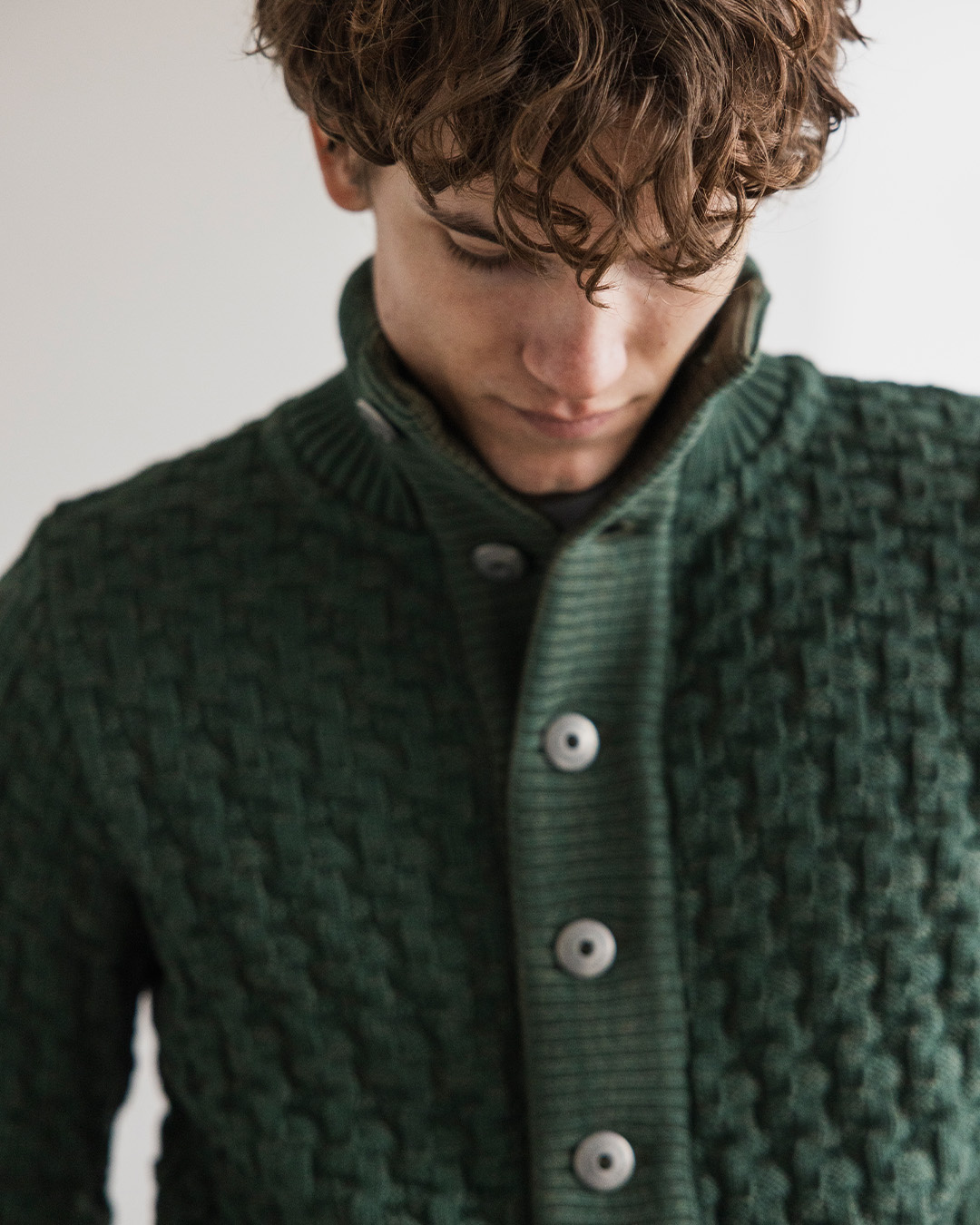Uomo in cardigan verde a trecce