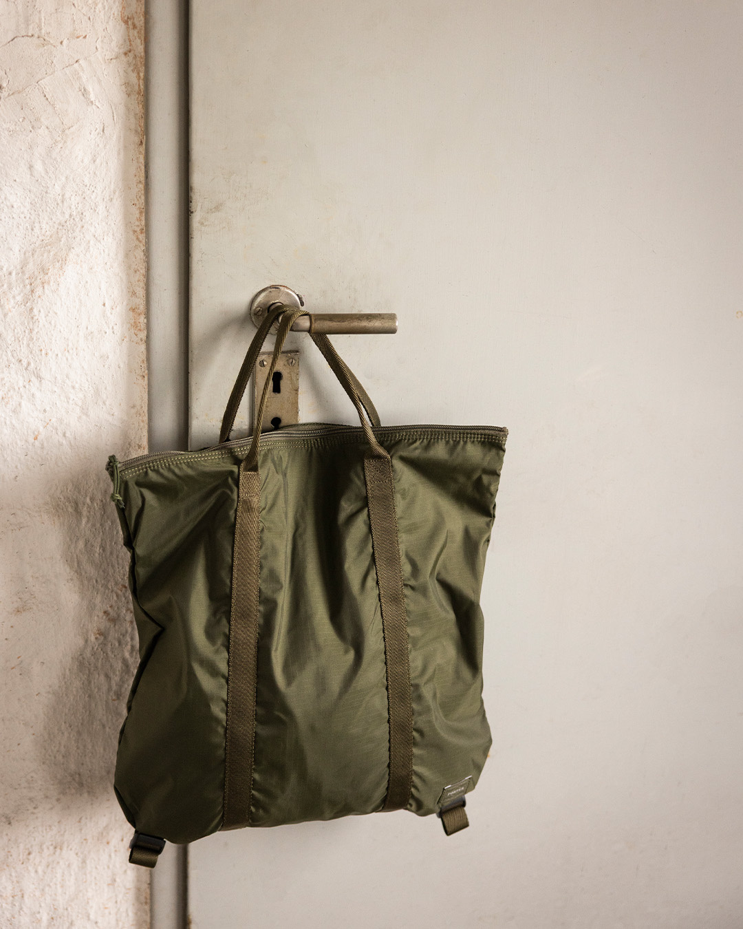Tote bag verde appesa a un gancio