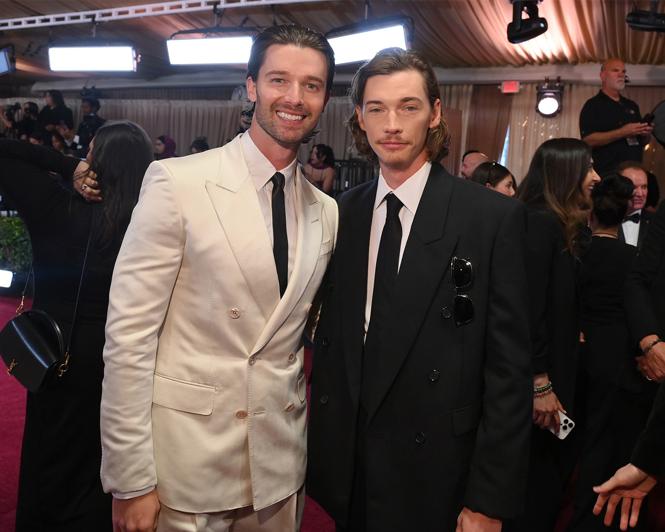 Patrick Schwarzenegger in abito chiaro accanto a Jacob Lofland in abito scuro sul red carpet
