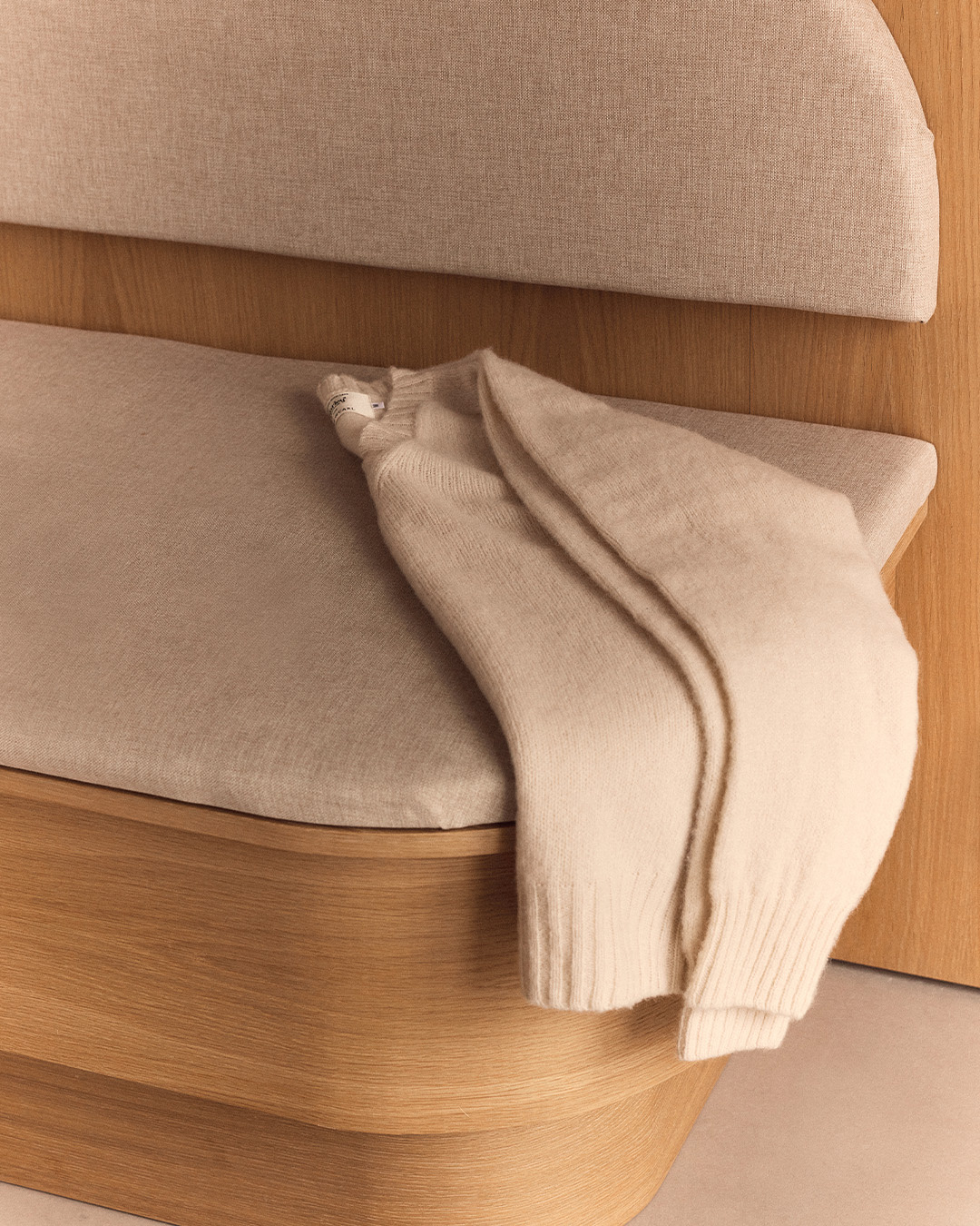Maglione beige appoggiato su una panca